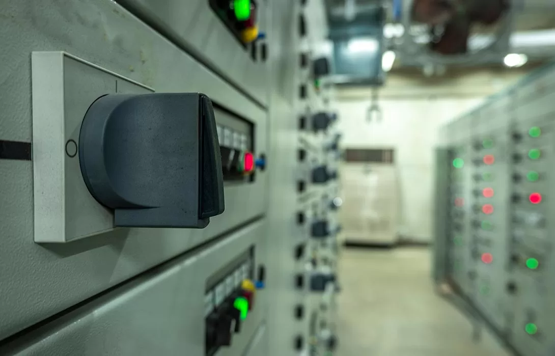 Foto de uma porta cinza de um painel CCM, com foco em uma chave de controle preta.